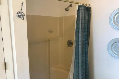 a shower with a blue shower curtain in a bathroom at 4 Bed 2 Bath Vacation home in Ossipee in Ossipee