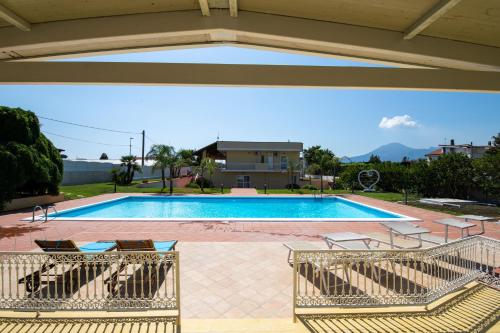 a swimming pool with chairs in front of a building at Villa Salvius in Scafati