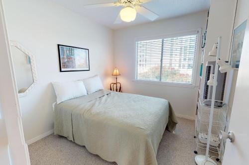 a white bedroom with a bed and a window at Southbay by the Gulf in Destin