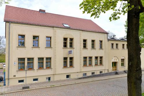 a large white building with a red roof at Hostel in Guben in Guben