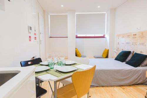 a room with a bed and a table and a couch at APOSENTUS - The Wine Studio in Porto