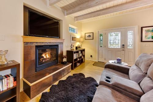 a living room with a fireplace and a flat screen tv at Gleneden Beach Escape in Gleneden Beach