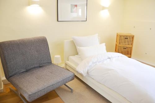 ein Schlafzimmer mit einem Bett und einem Stuhl in der Unterkunft Gästezimmer mit Garten in Fischeln in Krefeld