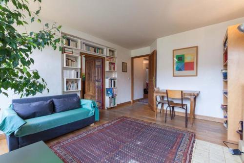 ein Wohnzimmer mit einem blauen Sofa und einem Tisch in der Unterkunft séjour Haut Marais in Paris