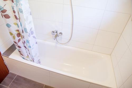 La salle de bains est pourvue d'une baignoire blanche avec rideau de douche. dans l'établissement Casa Susanna, à Wald-Michelbach