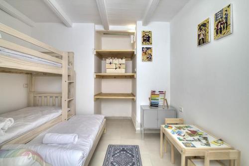 a bedroom with two bunk beds and a table at Rashbi 54 in Safed