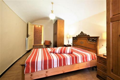 een slaapkamer met een bed met een rode en witte gestreepte deken bij da Patrick in Costarainera