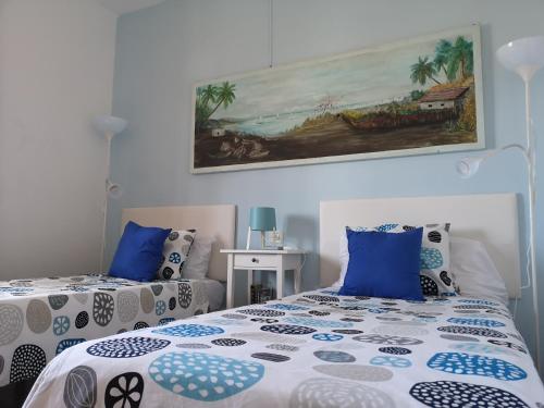 プエルト・デ・モガンにあるDailos' Homeのベッドルーム1室(ベッド2台付)が備わります。壁には絵画が飾られています。