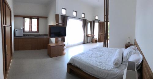ein Schlafzimmer mit einem Bett und einem Fernseher darin in der Unterkunft villa pulu uluwatu bali in Uluwatu