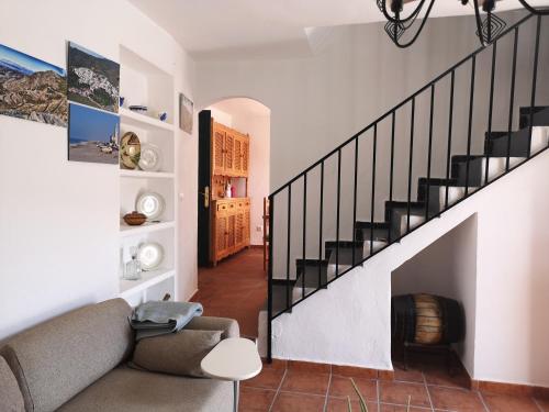 a living room with a staircase and a couch at Casa Rural El Chacho - Velefique in Velefique