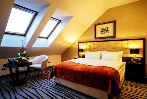 a bedroom with a large bed with a red blanket at Boutique Hotel Slávia in Košice