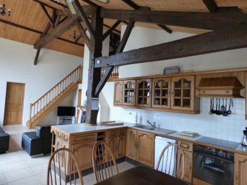 une cuisine avec des armoires en bois et un comptoir dans l'établissement Escale Vendéenne - Le Gîte 8 personnes, à Saint-Révérend