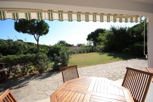 a patio with a table and chairs and a view of a yard at Albatros in Capoliveri