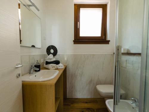 uma casa de banho com um lavatório, um WC e uma janela. em Discesa a Lago with terrace and garden on lake Iseo em Riva di Solto