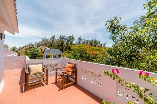 a balcony with two chairs and a table at An Bang Coco Villa in Hoi An