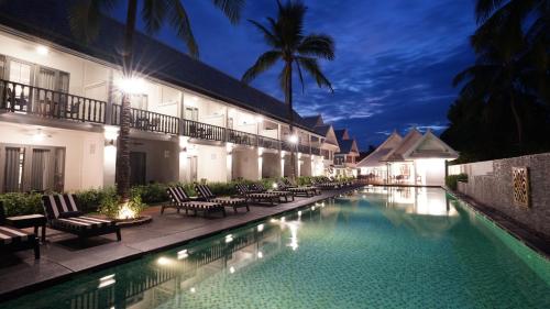 a swimming pool in front of a hotel at night at Souphattra Hotel in Luang Prabang