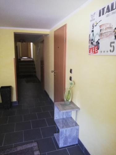 einen Flur mit Fliesenboden und einem Schild an der Wand in der Unterkunft Pension da Alessandro in Hemer