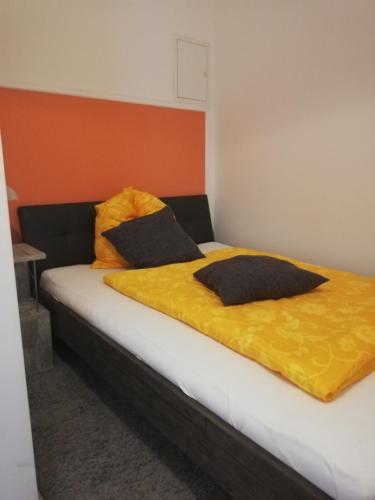 ein Bett mit zwei Kissen auf einem Zimmer in der Unterkunft Pension da Alessandro in Hemer