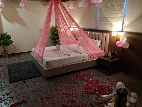 a bedroom with a bed with a pink mosquito net at Hotel Avaante Ahmedabad Formerly known as The Orchid Hotel in Ahmedabad