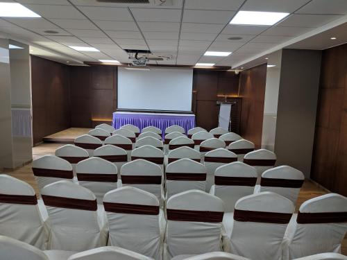 a conference room with a screen and chairs in it at Hotel Avaante Ahmedabad Formerly known as The Orchid Hotel in Ahmedabad
