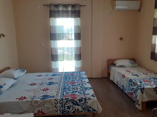 a bedroom with two beds and a window at Sunshine in Gevgelija