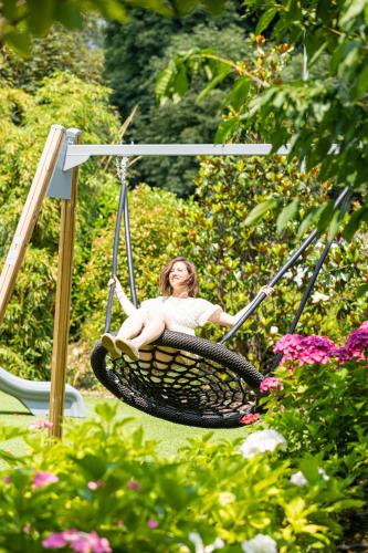 a woman sitting in a swing in a garden at Casa Bianca Apartments in Como