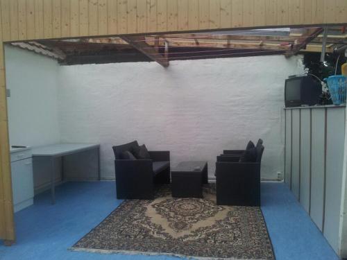 Zimmer mit 2 Stühlen, einem Tisch und einem TV in der Unterkunft Kleines Apartement zwischen Ega und Messe Erfurt in Erfurt