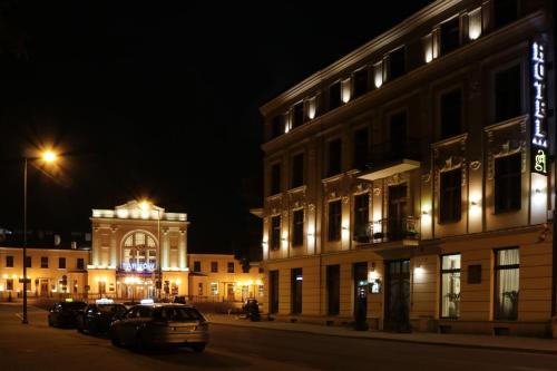 a city street at night with a building and cars at Hotel Gal in Tarnów