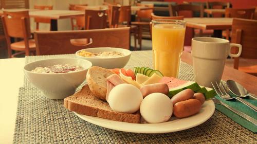 a plate of eggs and bread on a table with drinks at Park Hostel Osh in Osh