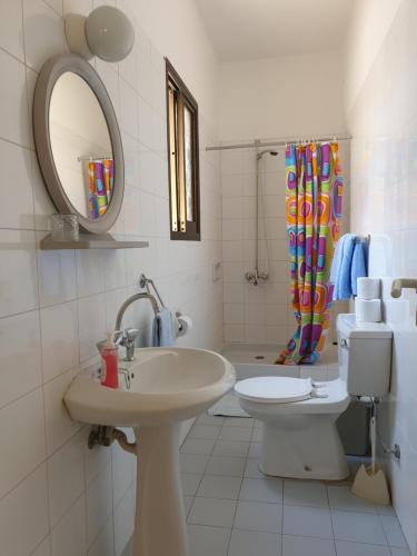 un bagno con lavandino, WC e specchio di Arilena Holiday Apartments a Paphos