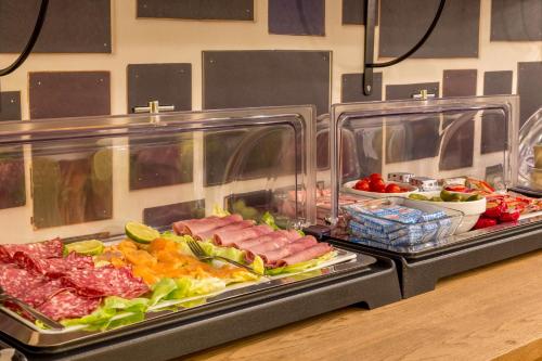 a buffet with meat and vegetables on a table at Best Western Hotel Centre Reims in Reims