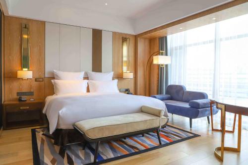 a bedroom with a bed and a chair and a desk at Pullman Changbaishan Resort in Fusong