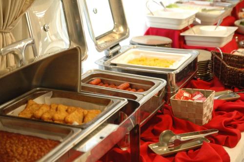a buffet with trays of food on a table at VR Queen Street Hotel & Suites in Auckland