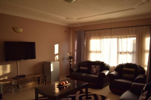 a living room with a couch and a table at Villa Prince in Harare