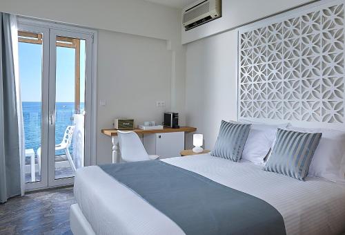 een slaapkamer met een bed en uitzicht op de oceaan bij Vasia Boulevard Hotel (Adults Only) in Chersonissos