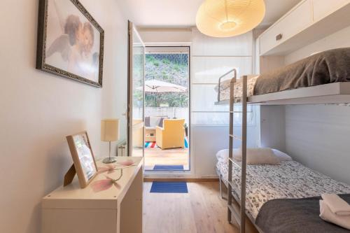 ein Schlafzimmer mit einem Etagenbett und einem Schreibtisch mit einem Spiegel in der Unterkunft Etxie La casa de Mundaka EBI 326 in Mundaka