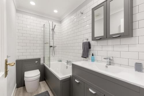 a white bathroom with a sink and a toilet at No 46 - by StayDunfermline in Dunfermline