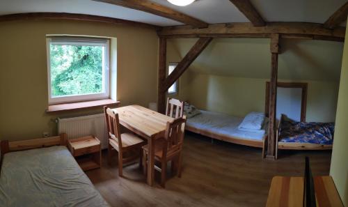 a room with two bunk beds and a table and chairs at Agroturystyka "Pod złotą rybką" in Wolany