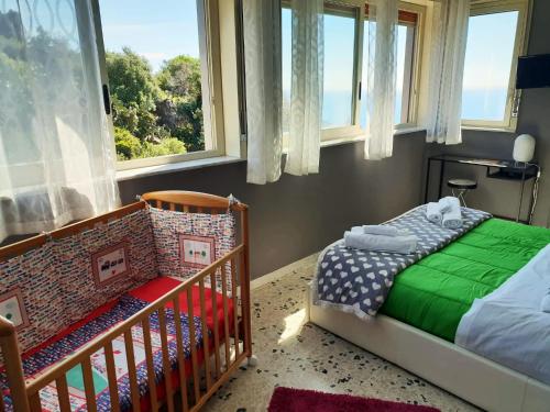a small bedroom with a crib and a window at La mia seconda casa ad Aci Castello in Aci Castello