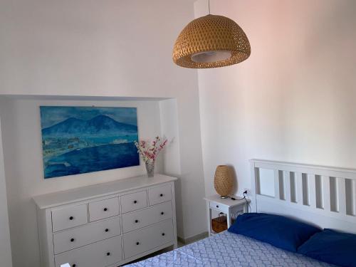 um quarto com uma cama e um quadro na parede em MAMA' em Anacapri