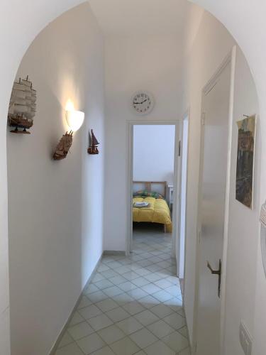 um corredor com um quarto com uma cama e um relógio em MAMA' em Anacapri