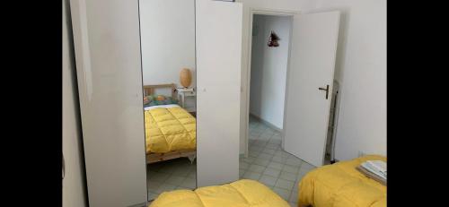 um quarto com uma cama amarela e um espelho em MAMA' em Anacapri