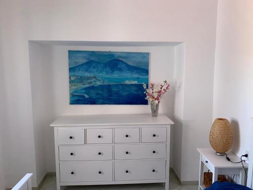 uma cómoda branca com uma pintura em cima em MAMA' em Anacapri