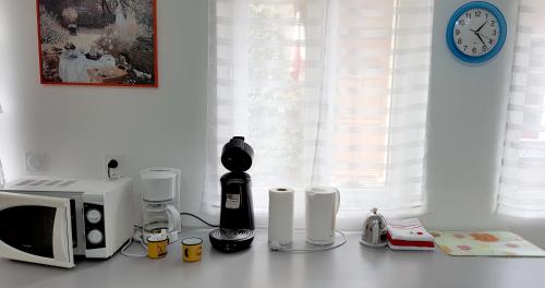 a kitchen counter with a microwave and a clock at Gîte la Providence in Saint-Sernin-du-Plain
