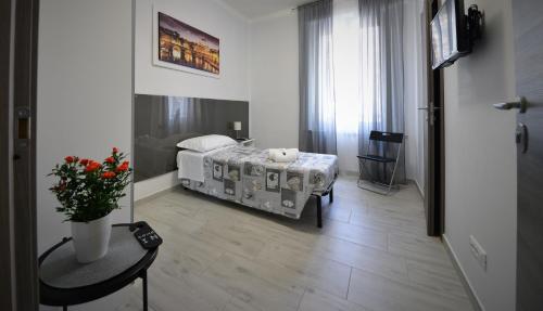 um quarto com uma cama e uma mesa com um vaso de flores em AFFITTACAMERE A CASA MIA em Roma