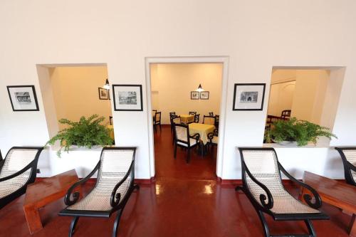a group of chairs in a room with a table at Heritage Belihuloya Resort in Belihul Oya