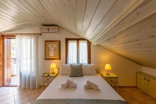 a bedroom with a large bed with two towels on it at Hotel Hera in Skala Potamias