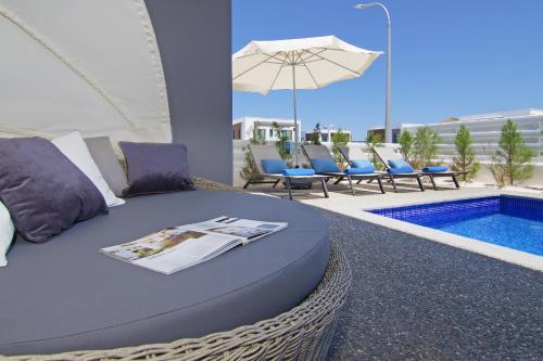 a bed with a magazine on it next to a swimming pool at Villa Melody in Protaras