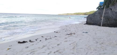 a sandy beach with people swimming in the ocean at Bara Village Guest House Bira in Bira