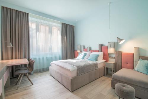 a bedroom with a bed and a desk and a couch at Ice Cream APARTMENTS in Sopot